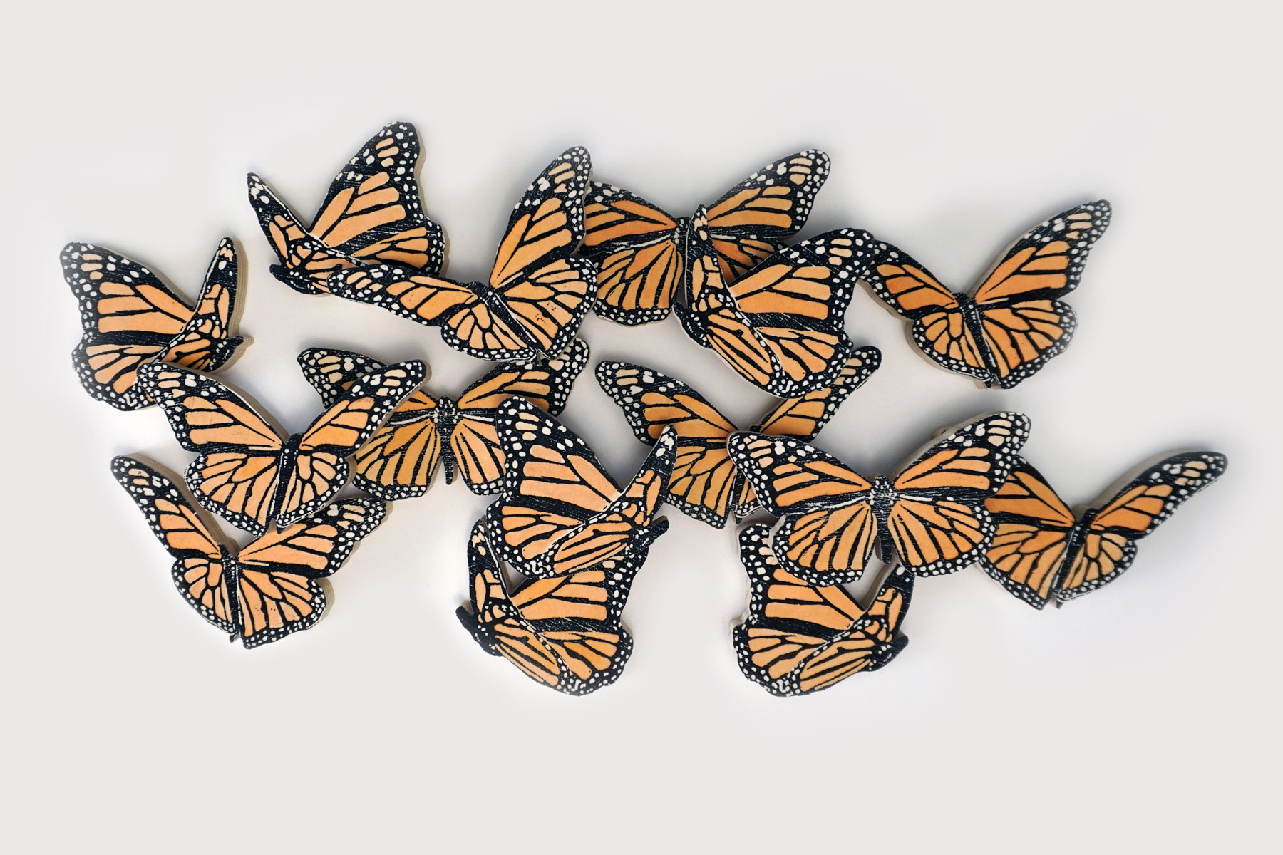 made out of woodcut prints and mix media, a small installation of 15 monarch butterflies in a cluster